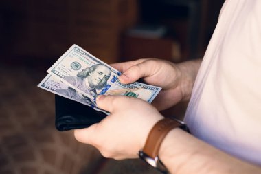 Bir adam içinde para ve kredi kartları olan bir cüzdan tutar.