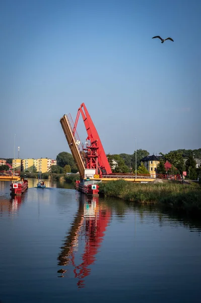 Dziwnow, Polonya - 10 Eylül 2021: Dziwna Kanalı üzerinde açık kırmızı bir köprü, denizden limana giden gemiler için giriş. 