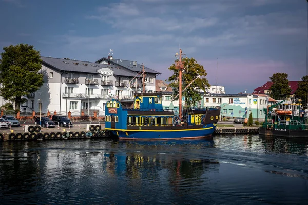 Dziwnow, Polonya - 10 Eylül 2021: Mavi ve sarı bir turist teknesi iskeleye demir attı. 