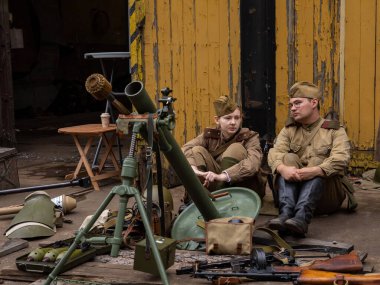 Wroclaw, Polonya - 19 Eylül 2021: 2. Dünya Savaşı 'ndan kalma askeri silahlarla çevrili, askeri üniforma giymiş iki Sovyet askeri. Breslau savunma yeniden yapılandırma grubu.