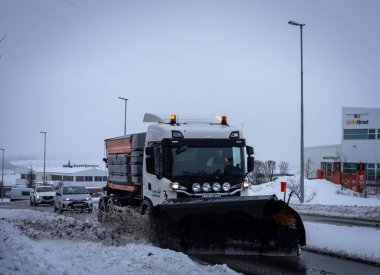 Reykjavik, İzlanda - 22 Mart 2022: Şiddetli kar yağışı sonrasında kar temizleyen bir kar temizleme aracı. Kış günü, bulutlu gökyüzü. 