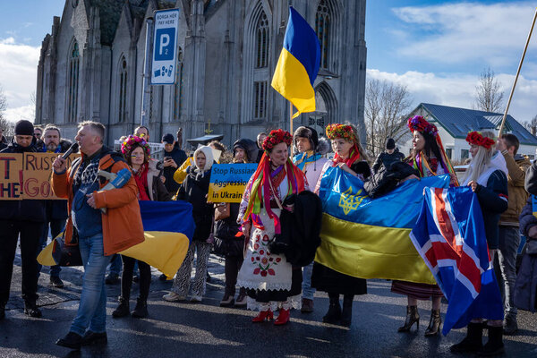 Reykjavik, Iceland - March 13, 2022: People carrying ukrainian colours and banners, protesting against war in Ukraine at a peaceful demonstration in front of Russian embassy in Reykjavik.
