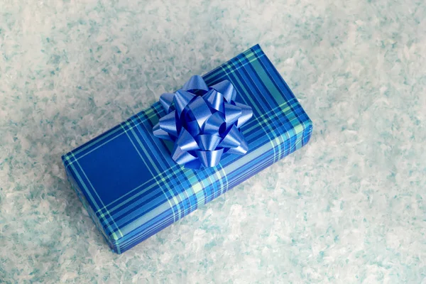 Blauwe geschenkdoos met een mooie strik in de sneeuw — Stockfoto