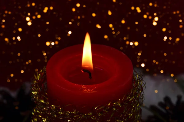A tűz egy karácsonyi gyertya az alkonyat egy csillogó háttér — Stock Fotó