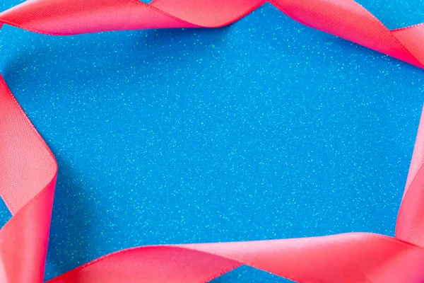 Sfondo glitter blu incorniciato con nastro di raso rosa — Foto Stock