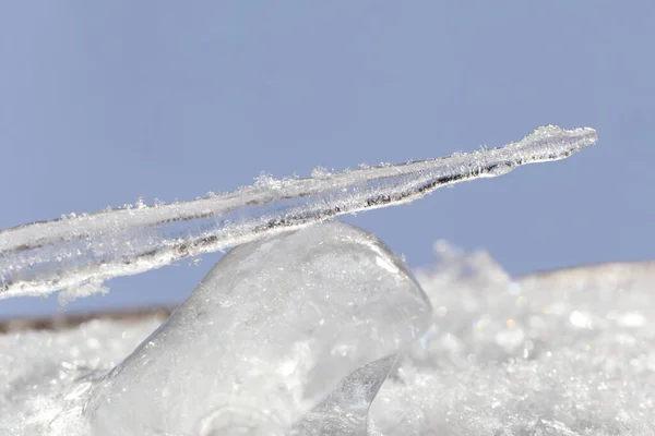 Een ijspegel op een blok ijs — Stockfoto