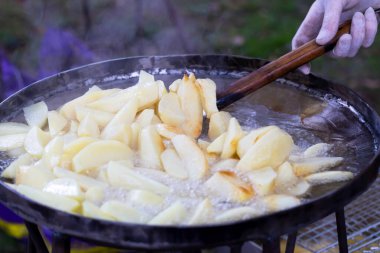 Patatesler dışarıda büyük bir tavada kızartılıyor.