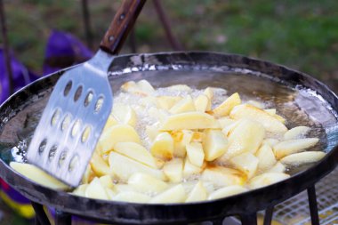 Sebze yağında patates kızartması, spatulayla karıştırılmış.