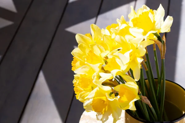 Fresh daffodils in a mug on the veranda — Foto de Stock