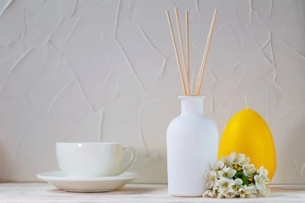 Çiçekler, mumlar ve fincanlarla beyaz bir zemin üzerinde Aromatik sazlık ayırıcı