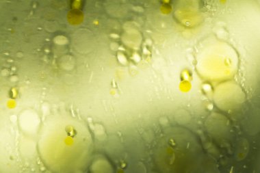 Yağ lekeleri, sarı arka planda suda daireler, basit bir güzellikte güzellik, her tasarım için bir çözüm. Seçmeli odak, ayrışma