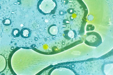 Mavi suda farklı boylarda bir sürü sarı yağ lekesi var. Her tasarım için desenli arka plan. Kozmos, fantezi, basitlikteki güzellik. Seçmeli odak, ayrışma