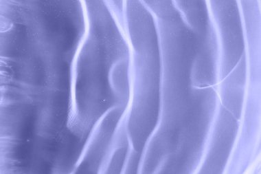 Violet, güneş ışığında suyun üzerindeki dalgaların dokusuna sahip. Yakın çekim, seçici odaklanma