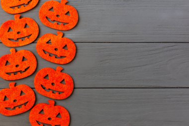 Cadılar Bayramı. Yapay balkabakları gri ahşap arka planda yatar. Düz yat, boşluğu kopyala