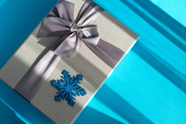 Šedá Dárková Krabice Lukem Modrou Sněhovou Vločkou Modrém Pozadí Vánoce — Stock fotografie
