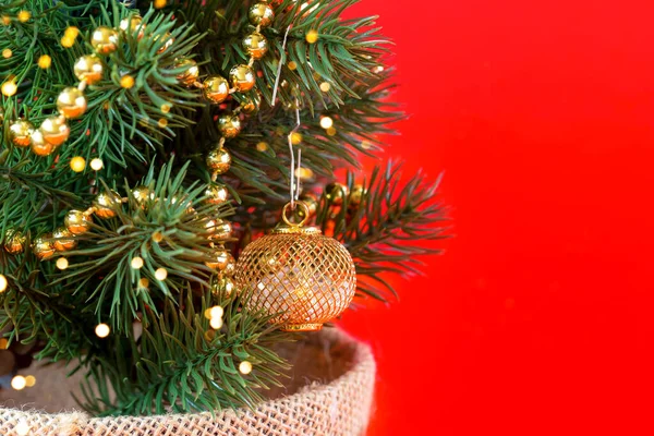Çelenklerde yapay Noel ağacı ve kırmızı arka planda süslemeleri var. Kopya alanı olan Yeni Yıl ve Noel arkaplanı