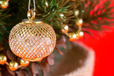 Noel ağacı süslemesi kapat. Kırmızı arka planda süslemeleri ve konisi olan bir tencerede yapay Noel ağacı