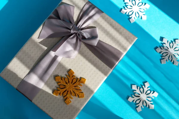 Серый Праздничный Подарочный Коробок Луком Несколькими Снежинками Синем Фоне Рождество — стоковое фото