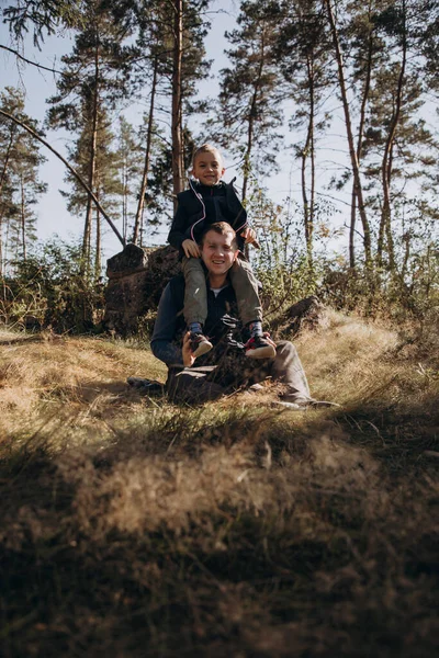Pojke och pappa har kul när de går i skogen på en solig dag — Stockfoto