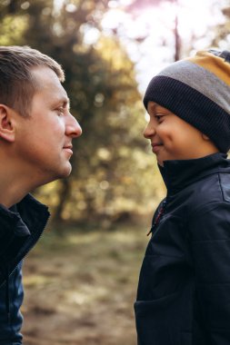 Neşeli baba ve oğul eğleniyor. Baba bankta oturur, ve çocuk surat asar.