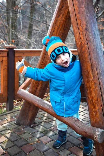 Calientemente vestido chico divirtiéndose en un paseo en un frío día soleado — Foto de Stock