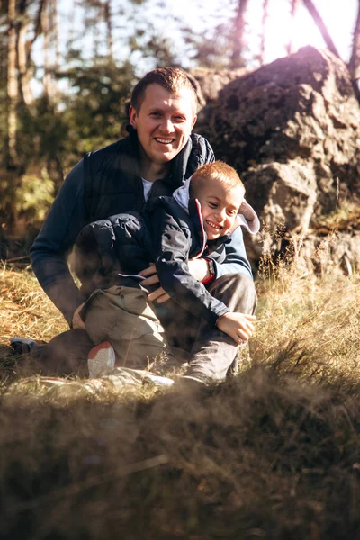Pojke och pappa har kul när de går i skogen på en solig dag — Stockfoto