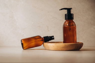 The concept of organic cosmetics. Bottles with face lotion on a beige background with a wooden plate