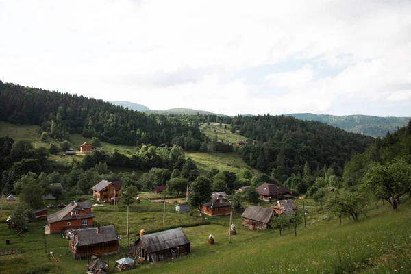 Dağ manzarası, dağdaki evler yeşil tepeler ve mavi gökyüzü
