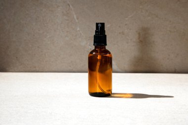 Işıklı arka planda gölgeli kozmetik bir şişe. Ön görünüm