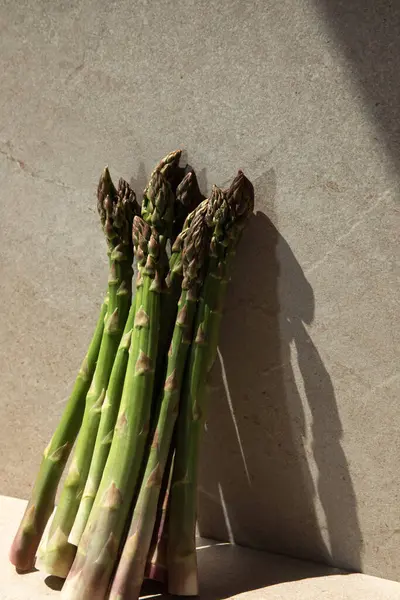 Frischer Grüner Spargel Auf Einem Beigen Steintisch Und Fensterschatten Frontansicht — Stockfoto