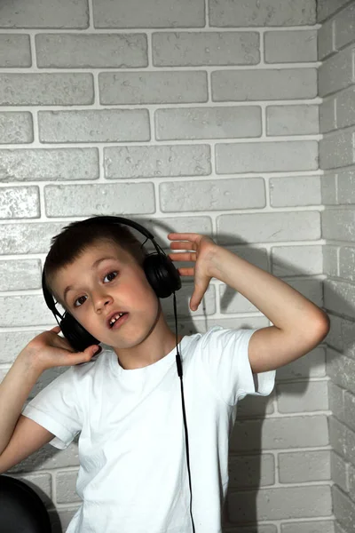 Chico Años Con Una Camiseta Blanca Escucha Música Auriculares Negros —  Fotos de Stock