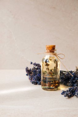 Lavanta yağı ve lavanta çiçekleri. Ön görünüm