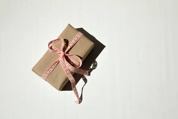 Dárková Krabice Kraftovém Papíru Svázaná Růžovou Krajkovou Stuhou Bílém Pozadí — Stock fotografie