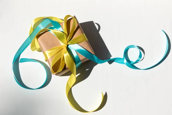 Gift Wrapped Kraft Paper Yellow Blue Ribbon Shadow White Background — 图库照片