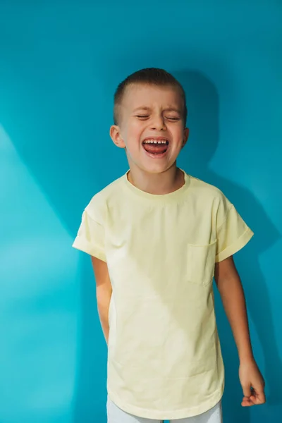 Year Old Boy Yellow Shirt Blue Background Shouts Loudly Portrait — Stock fotografie