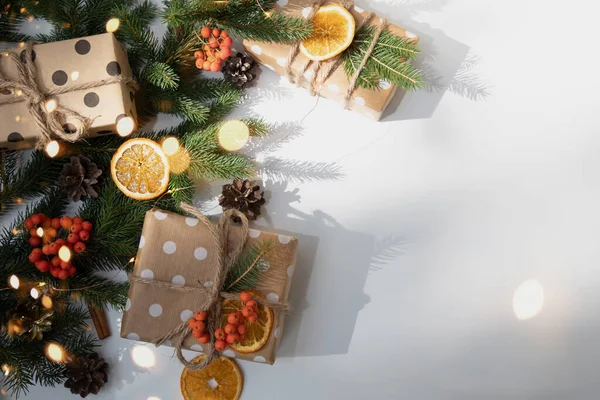 圣诞节的背景新年装饰在白色的背景上 枝头为绿色的圣诞树 松果和一片干橙和礼物 平躺在床上 — 图库照片