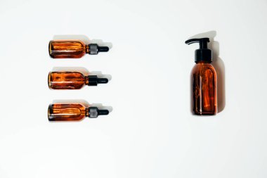 Beyaz arka planda doğal kozmetik ürünleri olan bir grup kehribar rengi. Düz yatıyordu