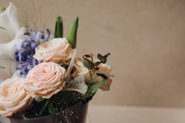 Bir buket çiçek, güller, yıldız çiçekleri, parlak taşlı arka planda güzel pembe bir paket içinde gladioli. Ön görünüm