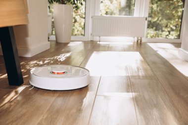 Robot elektrikli süpürge ev temizliği yapıyor. Temizlik için modern teknolojinin kullanımı. Ön görünüm