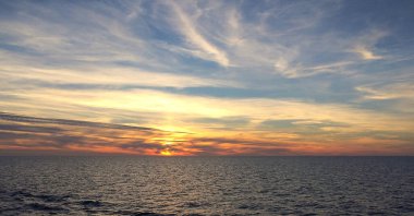 Dramatik gökyüzü, okyanusta inanılmaz güzel bir gün batımı.