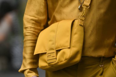 Milan, İtalya - 22 Eylül 2021: Sokak tarzı kıyafet, sarı hardallı Fendi tişört giyen şık kadın, sarı hardallı Fendi şort, Milano, İtalya sokaklarında sarı naylon Fendi çanta.