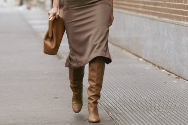 Milan, İtalya - 22 Eylül 2021: Sokak tarzı kıyafet, Fendi 'den altın büyük kolye takan şık bir kadın, Fendi' den altın zincirli bir FF kolye, siyah çizgili kahverengi ve FF monogramlı kesilmiş gömlek, bej balon h