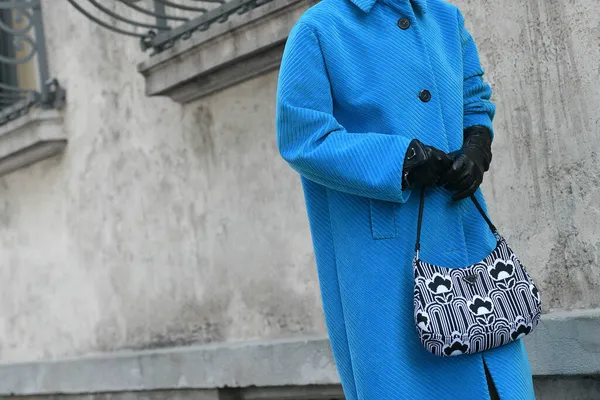 Milan, İtalya - 24 Eylül 2021: Sokak tarzı kıyafet, Prada kıyafetli şık kadın: mavi ceket, eldiven, çanta Milano, İtalya sokaklarında.