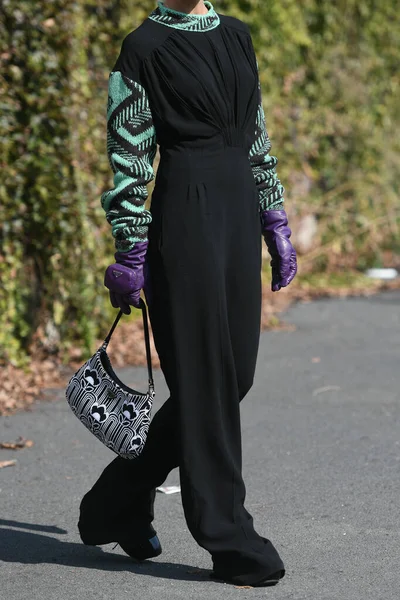 Milan, İtalya - 24 Eylül 2021: Sokak tarzı kıyafet, siyah bir Prada bluz, siyah pantolon, mor uzun eldivenler ve İtalya 'nın Milano sokaklarında Prada çanta giyen şık kadın.