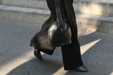 Milan, İtalya - 23 Eylül 2021: Sokak tarzı kıyafet, beyaz gömlek giyen şık bir kadın, siyah ceket, siyah büyük pantolon, Emporio Armani 'den deri bir çanta, ve topuklu ayakkabılar..
