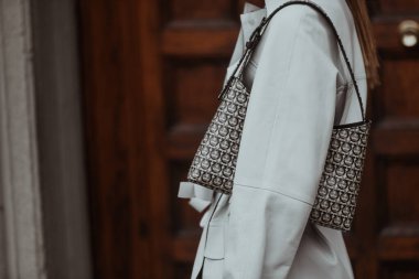 Milan, İtalya - 22 Eylül 2021: Sokak tarzı kıyafet, krem rengi beyaz ceket giyen şık kadın, Milan, İtalya sokaklarında baskı ve bot dolu çanta.