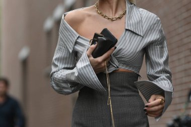 Milan, İtalya - 22 Eylül 2021: Sokak tarzı kıyafet, çizgili bluz giyen şık kadın, gri, mikro çantalı yüksek bel etek, Milano, İtalya sokaklarında güneş gözlüğü.