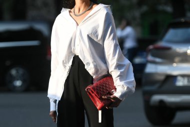 Milan, İtalya - 23 Eylül 2021: Sokak tarzı kıyafet, beyaz gömlek ve kırmızı Chanel çanta giyen şık kadın Milano, İtalya sokaklarında.