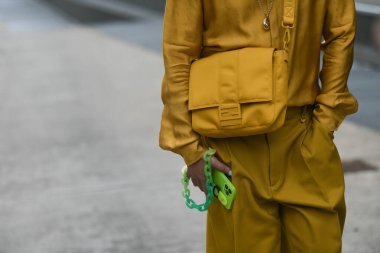 Milan, İtalya - 22 Eylül 2021: Sokak tarzı kıyafet, sarı hardallı Fendi tişört giyen şık kadın, sarı hardallı Fendi şort, Milano, İtalya sokaklarında sarı naylon Fendi çanta.