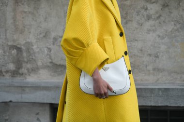 Milan, İtalya - 24 Eylül 2021: Sokak tarzı kıyafet, sarı Prada giysili şık bir kadın, Milano, İtalya 'da beyaz çanta.